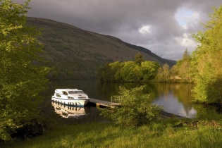 Escocia - Barco sin licencia Magnifique atracado en uno de los muchos lagos del Canal de Caledonia que cruza Escocia